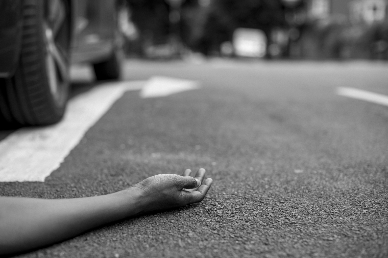 Person lying ground after car accident